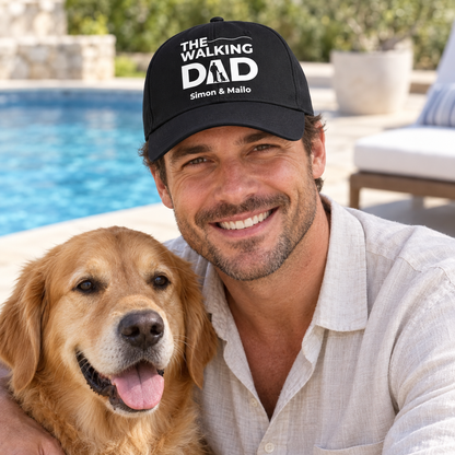 Black cap with “THE WALKING DAD” print and personalized names, worn by a man with a dog.