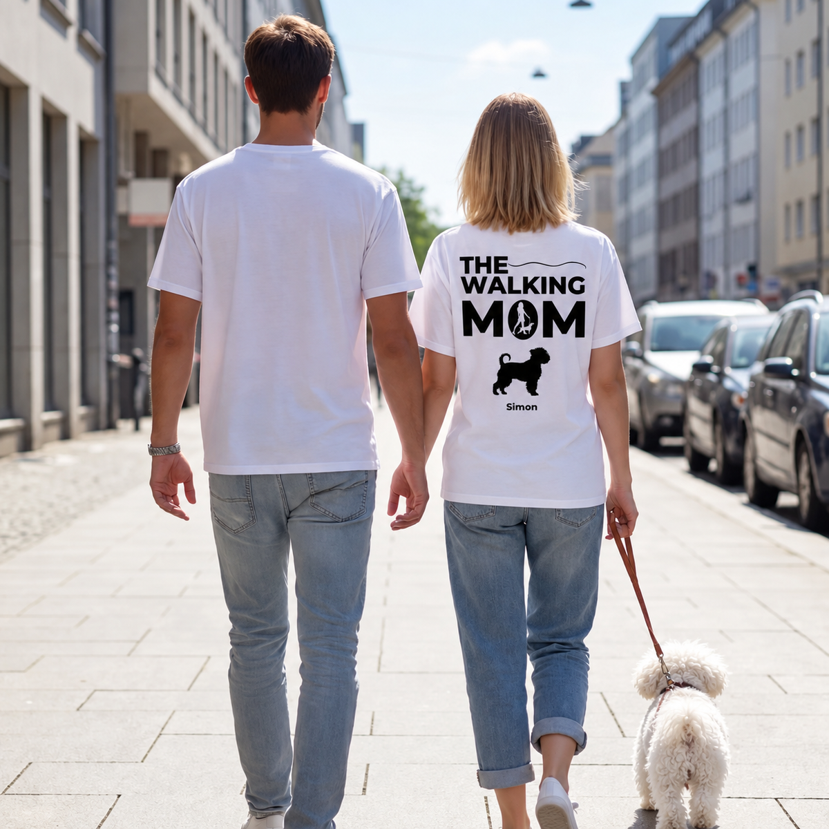 Two people wearing white T-shirts printed with "THE WALKING MOM" and a dog, on a street.