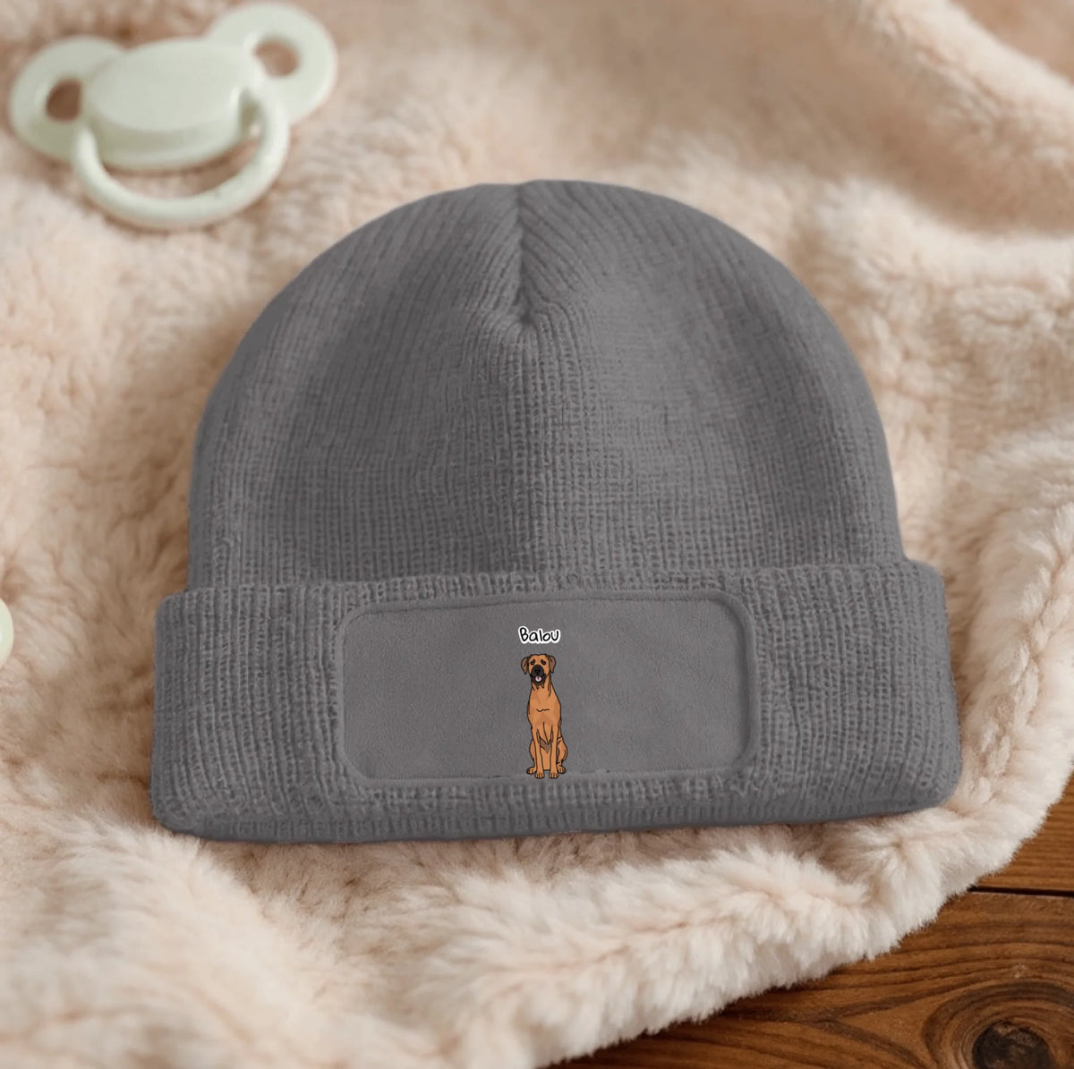 Grey knitted beanie with personalized patch and dog design.