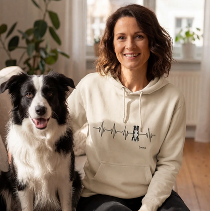 Beige hoodie with heartbeat design and personalized lettering, worn by a woman next to a dog.