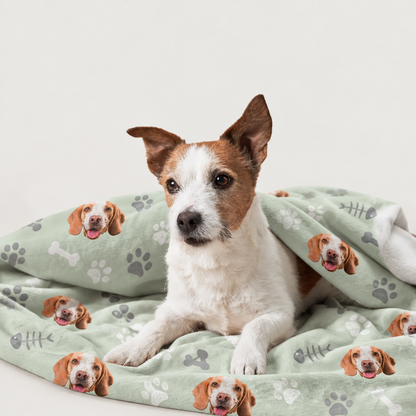 Personalized pet blanket with green background and printed dog motifs, wrapped around a dog.