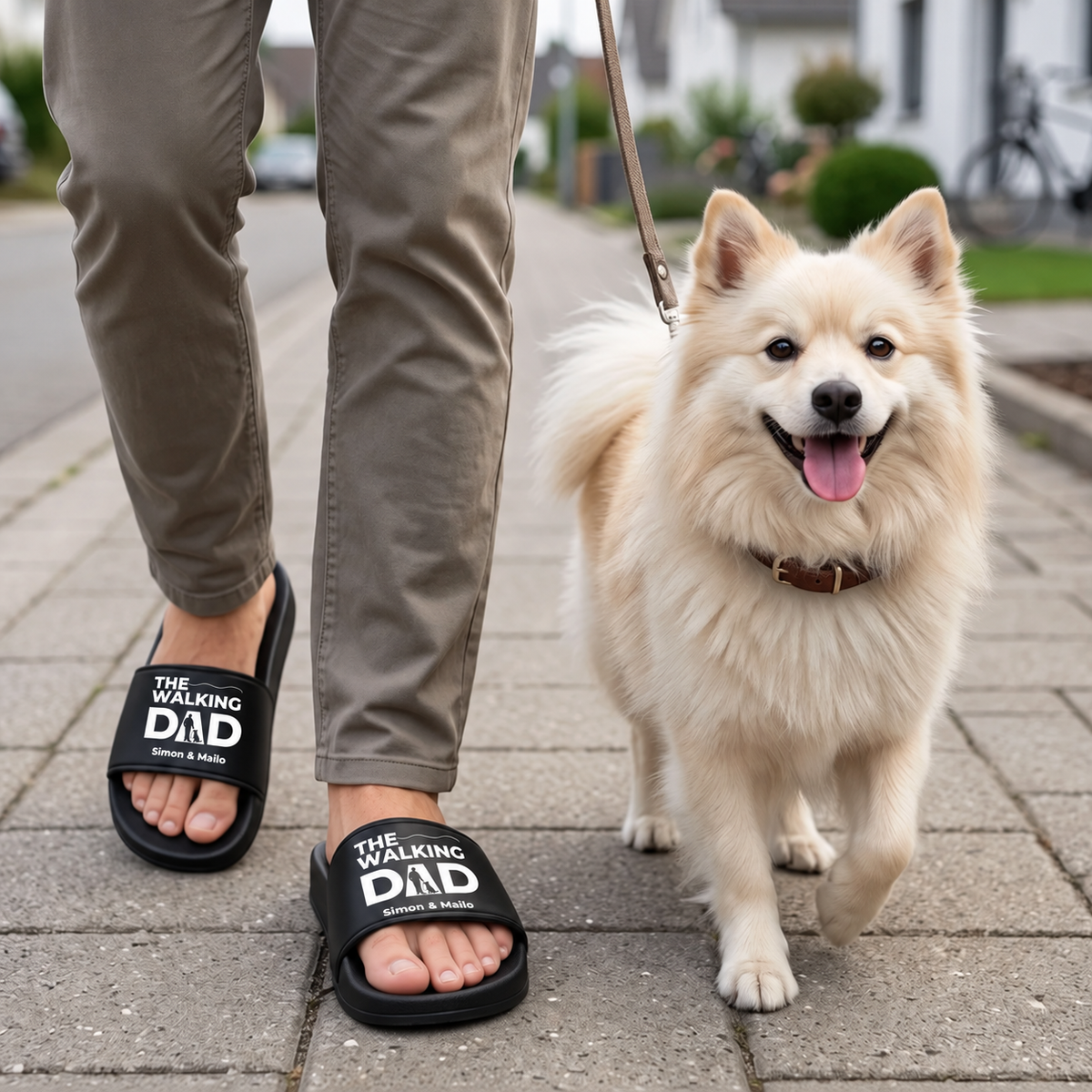 Person wearing personalized black slides with "THE WALKING DAD" print, walking a dog.